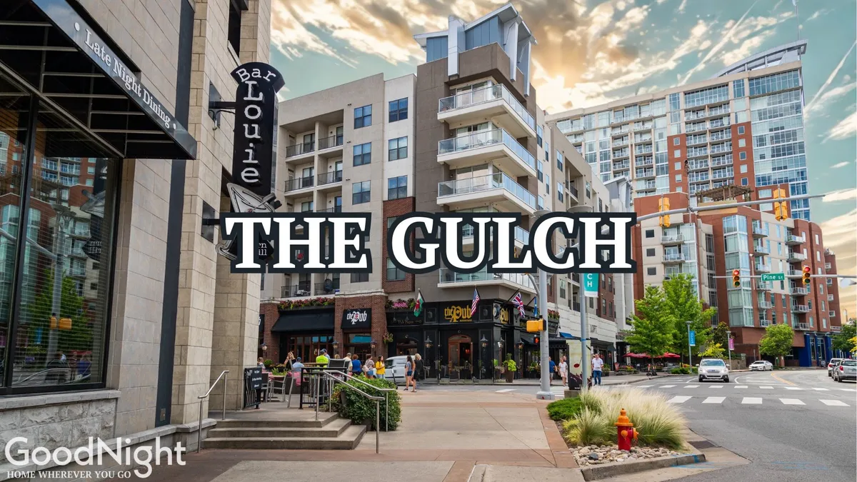 A vibrant street scene in The Gulch, showcasing Bar Louie, modern apartment buildings, greenery, and the iconic ‘The Gulch’ sign. People are seen dining, shopping, and strolling, capturing the dynamic energy of Nashville’s local dining and entertainment scene.
