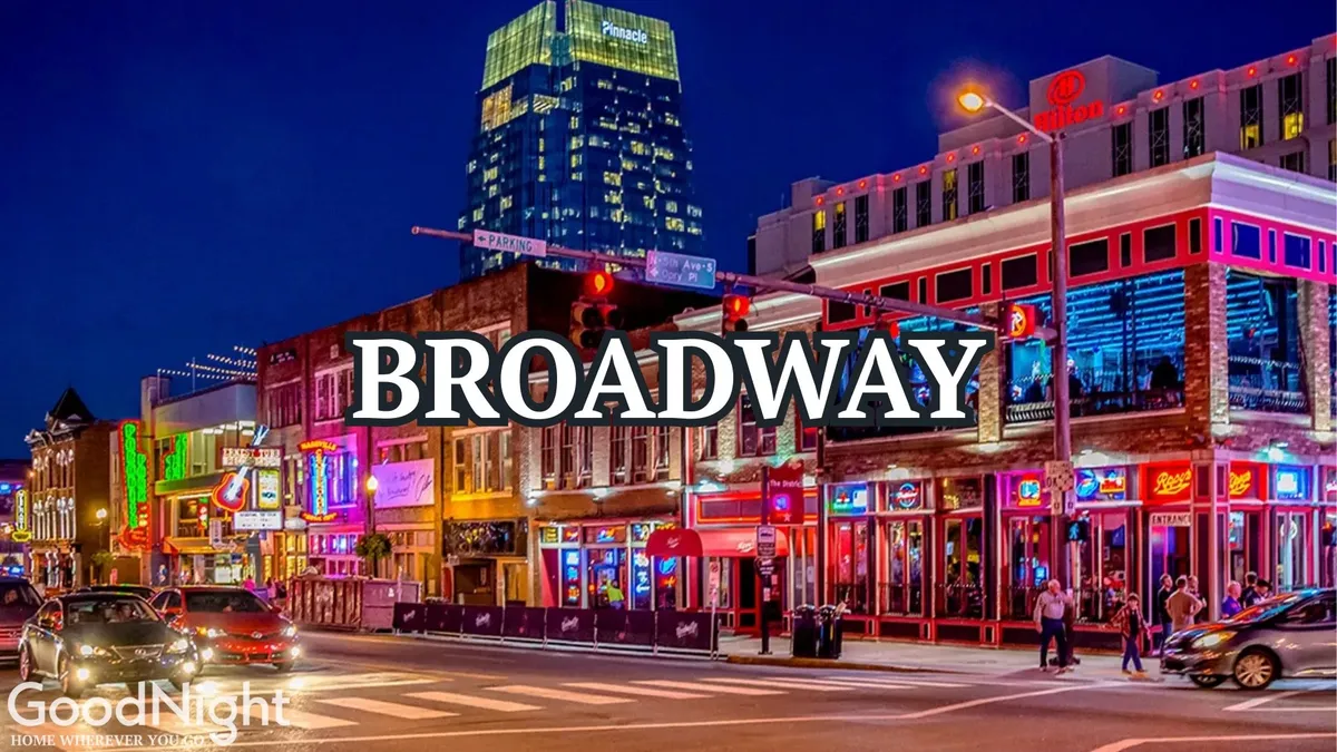 A bustling nighttime street scene in downtown Nashville, alive with colorful neon signs illuminating the facades of bars, honky-tonks, and local shops. Crowds of people can be seen strolling the sidewalks, soaking in the energetic atmosphere and vibrant city life. The neon glow reflects off the pavement, creating a quintessential 'Nashville after dark' vibe.