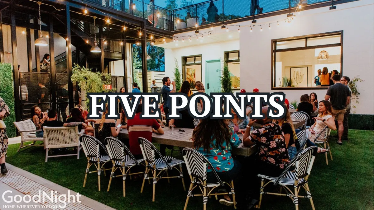 An outdoor dining area under string lights, filled with people socializing and enjoying shared meals. The scene feels festive and communal, evoking the pleasure of gathering with friends to savor local cuisine in a lively open-air environment.